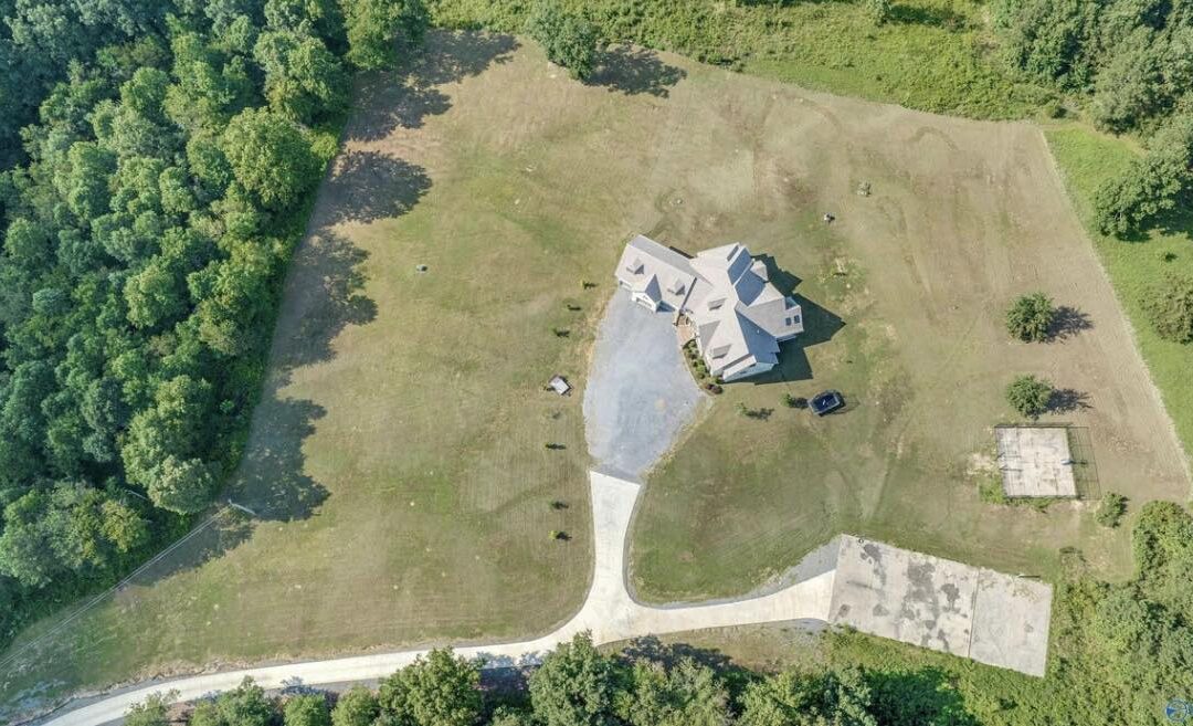 aerial photo of large estate home in a secluded wooded lot